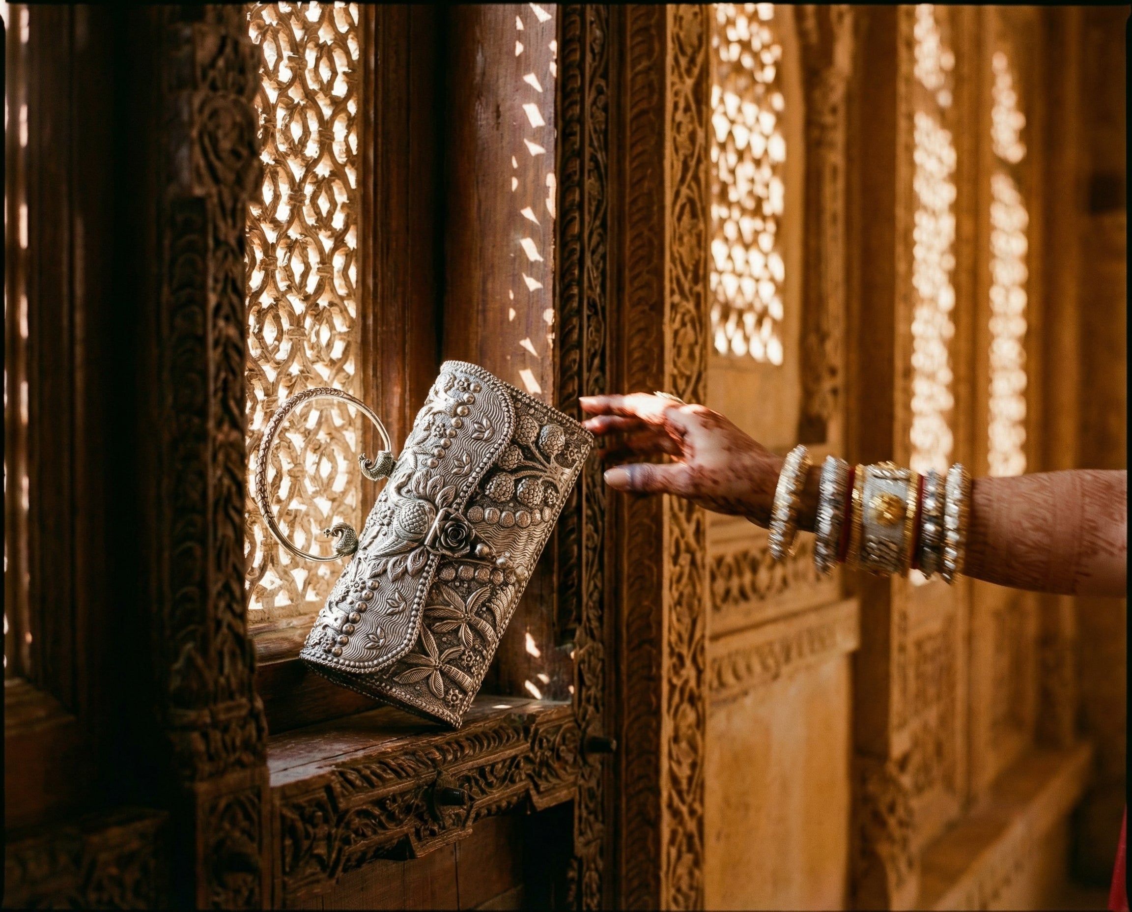 Silver handbag beside a carved palace window