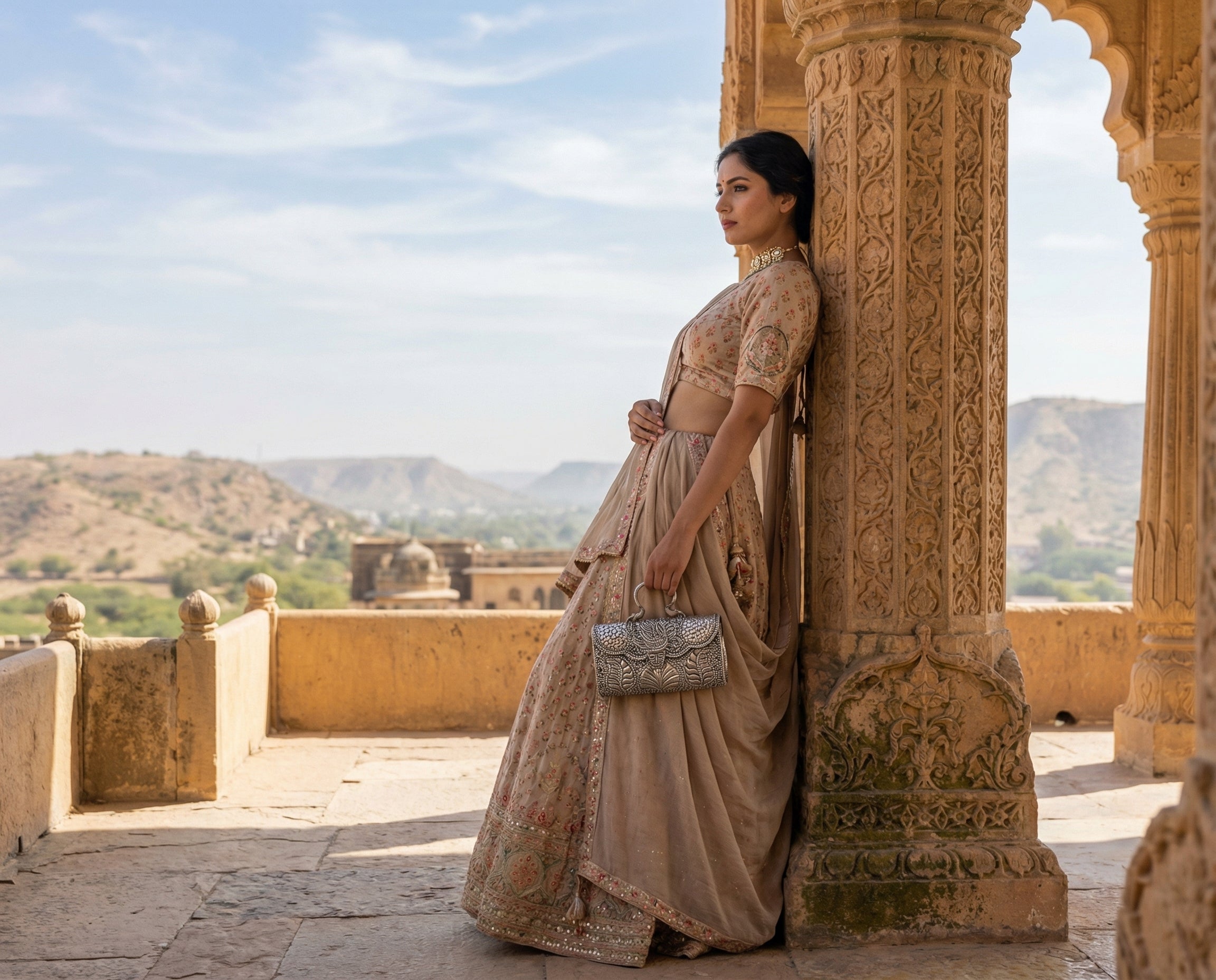 Model carrying a silver handbag beside a carved Rajasthan palace pillar, from the original Candrin homepage