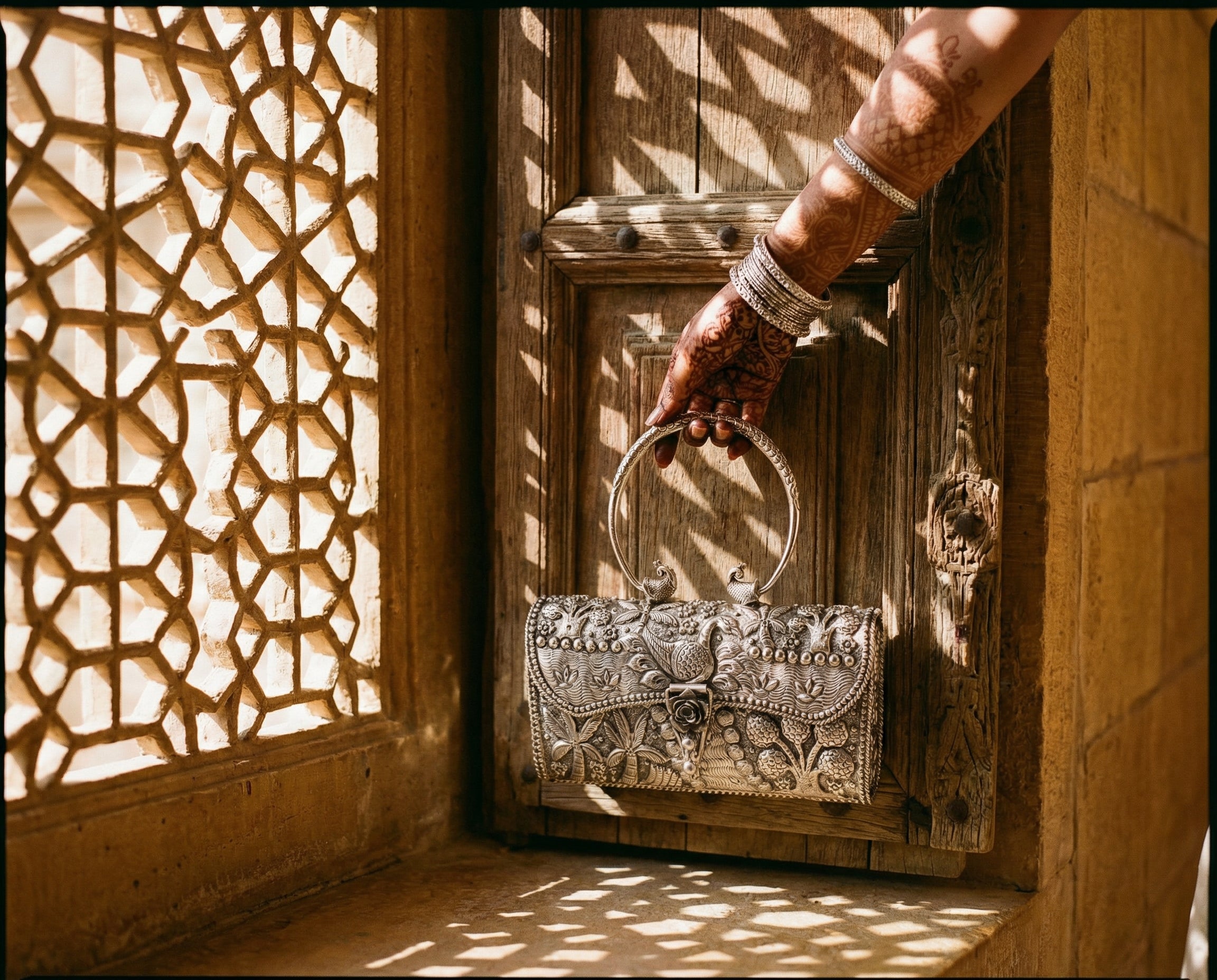 Silver handbag held against a carved wooden door