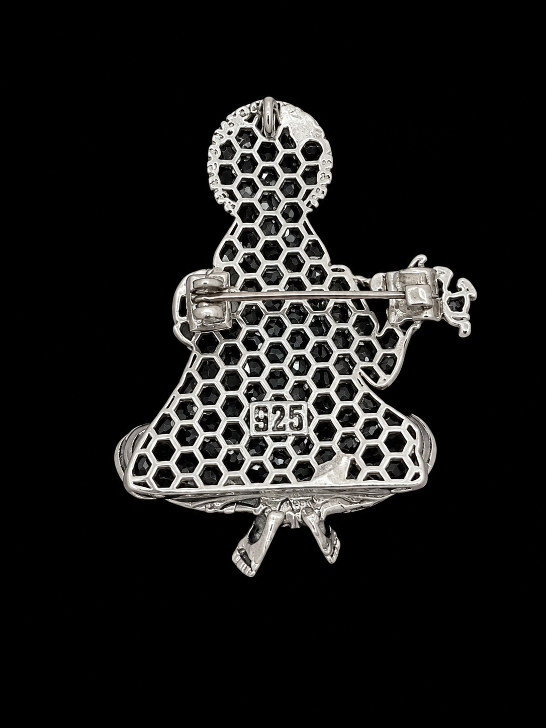 A silver-tone safety pin brooch shaped like a seated figure, featuring a honeycomb pattern with small black stones and a '925' silver purity stamp, shown against a solid black background.